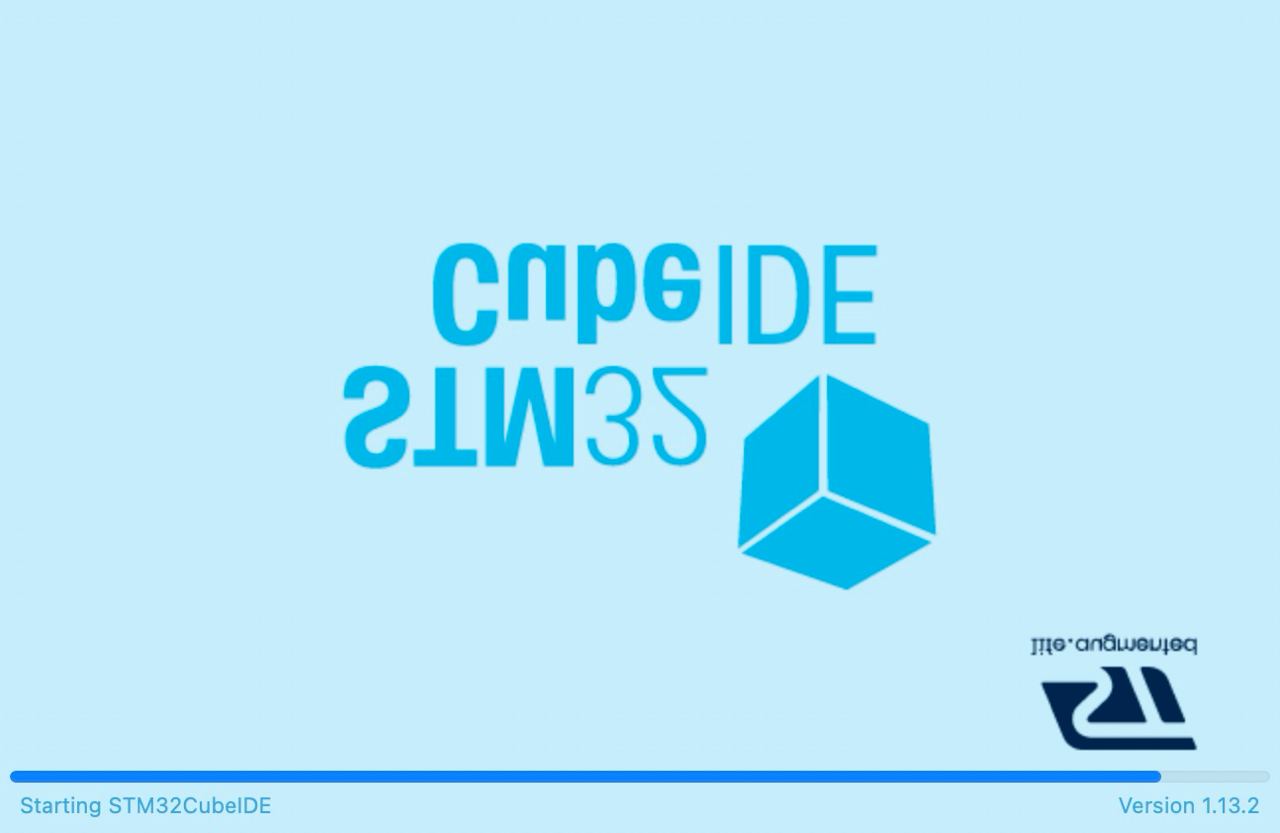 A splash screen displaying "STM32CubeIDE" in mirrored and regular text, with a graphic of a 3D cube and a logo. The screen indicates the program is starting and shows the version number 1.13.2 at the bottom. There's also a smaller logo for STMicroelectronics in reverse at the bottom right.